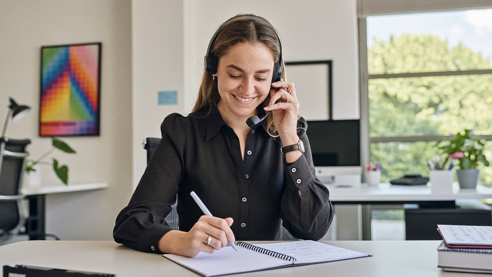 A licensed Saving Day advisor on a call, taking notes on a plan comparison